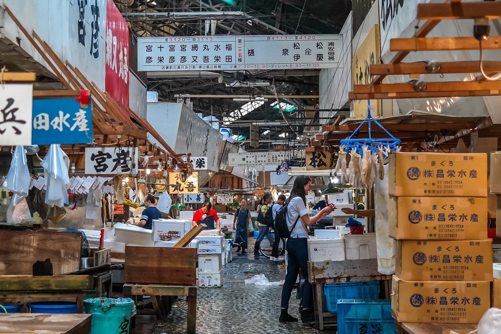 Tsukiji fish market interior with vendors and seafood stalls and Japanese signage
